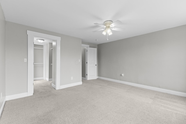 1093 E Long St, Columbus, OH 43203 - unfurnished bedroom with light carpet, a spacious closet, baseboards, a ceiling fan, and a closet