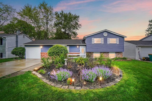 1008 London Rd, West Jefferson, OH 43162 - tri-level home featuring concrete driveway, brick siding, a lawn, and an attached garage