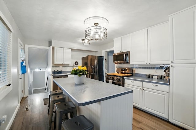 1008 London Rd, West Jefferson, OH 43162 - kitchen with appliances with stainless steel finishes, a breakfast bar, white cabinets, and wood finished floors