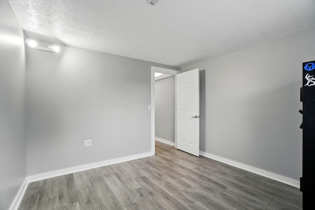 1008 London Rd, West Jefferson, OH 43162 - unfurnished room with wood finished floors, baseboards, and a textured ceiling