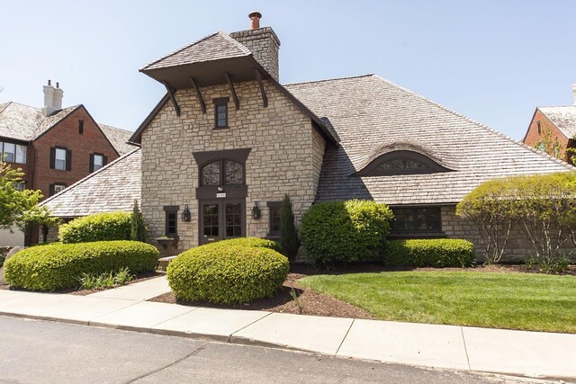 6077 Craughwell Ln, Dublin, OH 43017 - view of front of home with stone siding, a front lawn, and a chimney