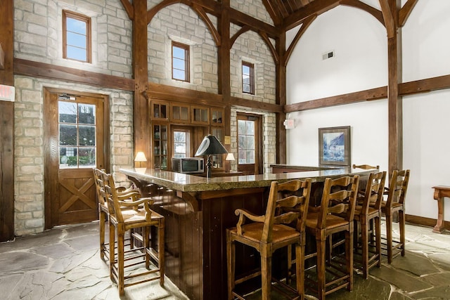 6077 Craughwell Ln, Dublin, OH 43017 - indoor bar featuring stone flooring and high vaulted ceiling
