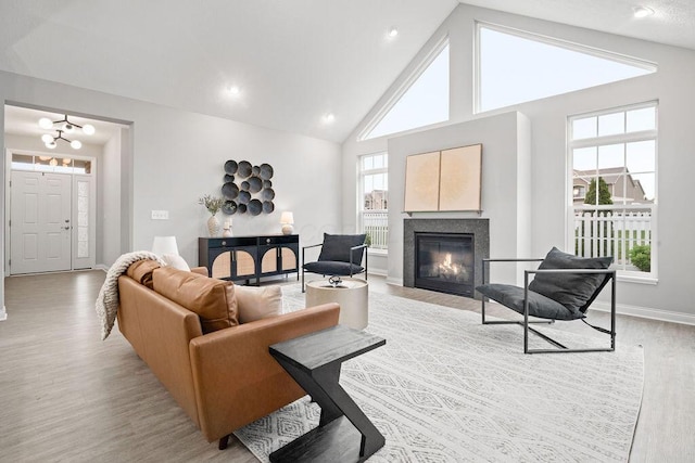 5165 Hamptonshire Dr, Dublin, OH 43016 - living area featuring light wood-type flooring, high vaulted ceiling, a chandelier, a glass covered fireplace, and baseboards