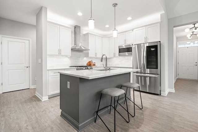 5165 Hamptonshire Dr, Dublin, OH 43016 - kitchen with stainless steel appliances, wall chimney exhaust hood, baseboards, light wood finished floors, and recessed lighting
