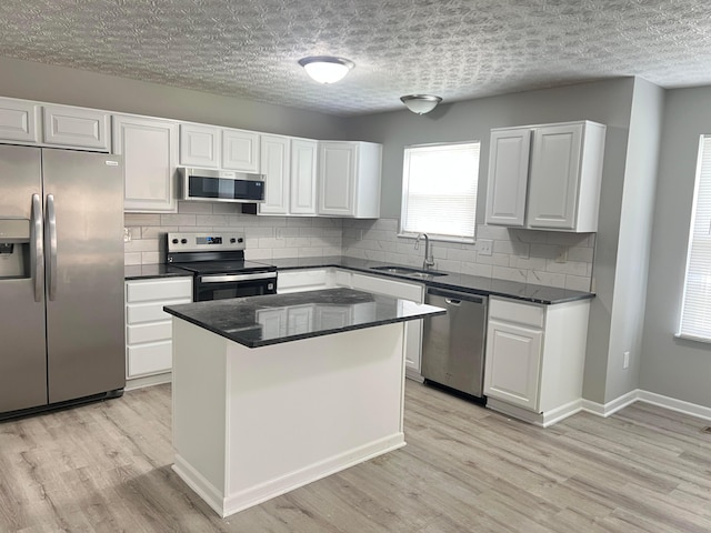 5966 Twin Pine Dr, New Albany, OH 43054 - kitchen featuring stainless steel appliances, a sink, backsplash, and white cabinetry