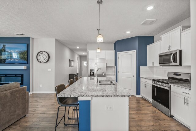 759 Abby Dr, Plain City, OH 43064 - kitchen featuring stainless steel appliances, a sink, decorative backsplash, a kitchen breakfast bar, and dark wood finished floors