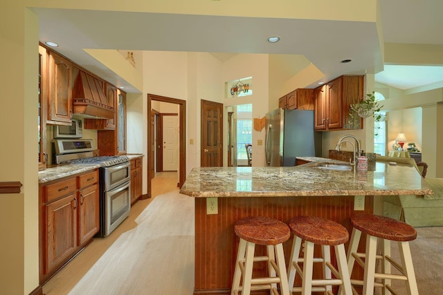 3695 Britton Ave, Columbus, OH 43204 - kitchen with appliances with stainless steel finishes, a sink, a breakfast bar area, light stone countertops, and recessed lighting