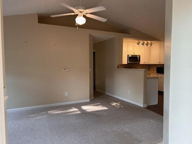 6855 Falcon Ln Unit 4A, Canal Winchester, OH 43110 - kitchen with stainless steel microwave, ceiling fan, dark colored carpet, tasteful backsplash, and white cabinets
