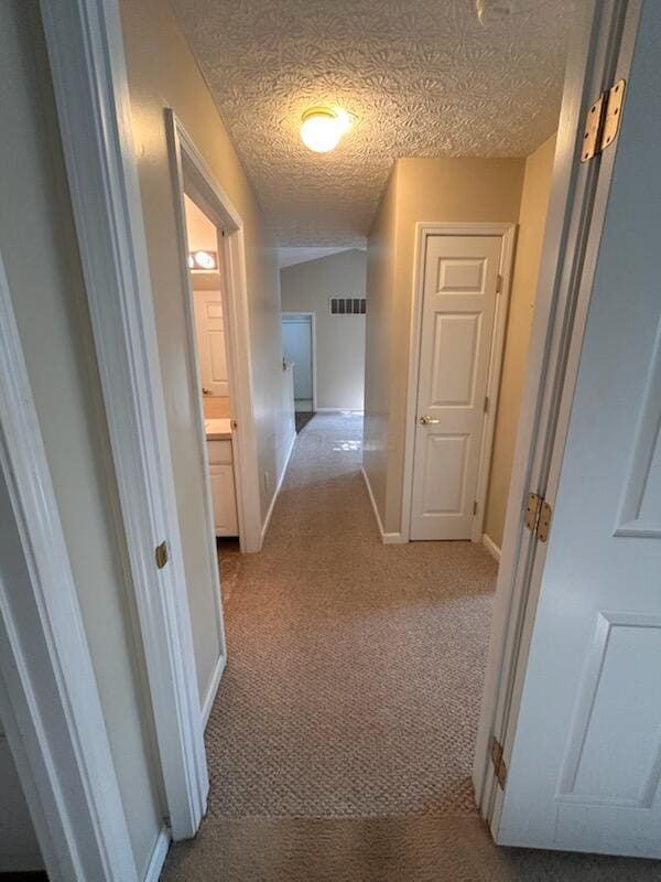 6855 Falcon Ln Unit 4A, Canal Winchester, OH 43110 - hallway with light carpet, baseboards, and a textured ceiling