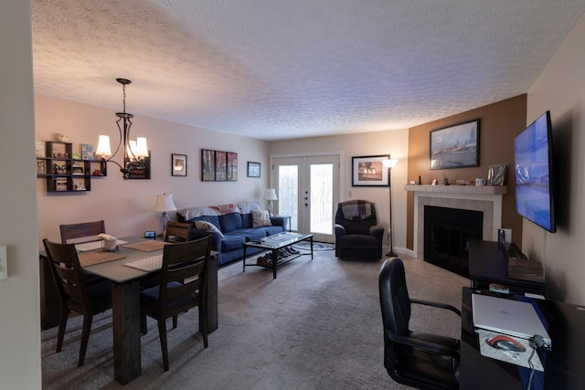 5392 Ponderosa Dr, Columbus, OH 43231 - carpeted dining room featuring a textured ceiling, a chandelier, a fireplace, and french doors