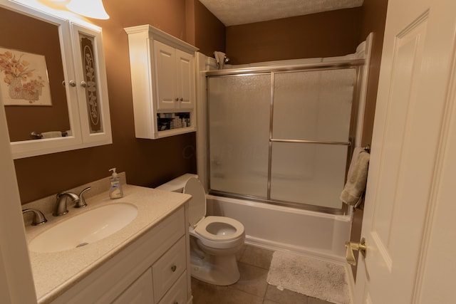 5392 Ponderosa Dr, Columbus, OH 43231 - bathroom with vanity, toilet, shower / bath combination with glass door, tile patterned floors, and a textured ceiling