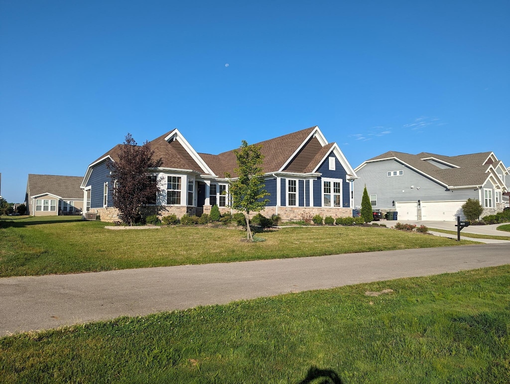 3677 Audubon Ave, Hilliard, OH 43026 - view of front of property with a front lawn, stone siding, and a garage