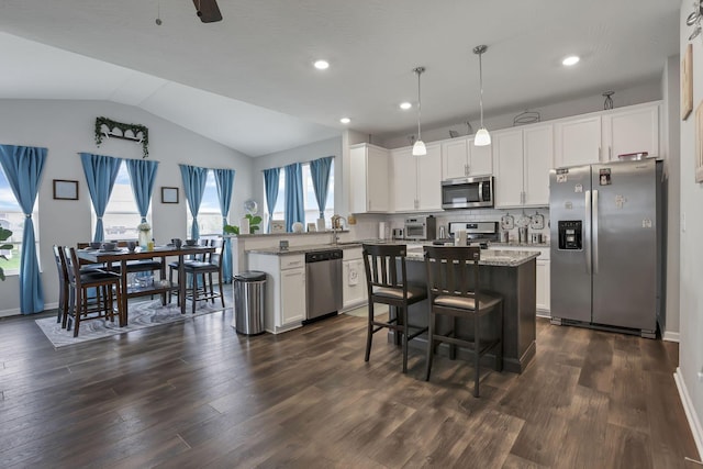 4196 Holstein Dr, Obetz, OH 43207 - kitchen featuring appliances with stainless steel finishes, dark wood-style flooring, a peninsula, white cabinets, and lofted ceiling