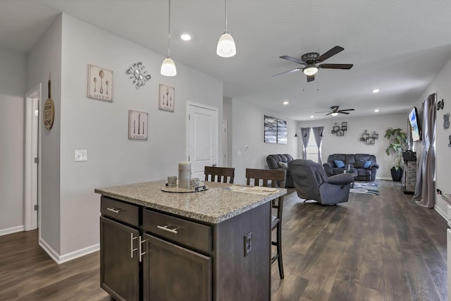 4196 Holstein Dr, Obetz, OH 43207 - kitchen featuring a kitchen bar, ceiling fan, dark wood-style flooring, dark brown cabinetry, and baseboards