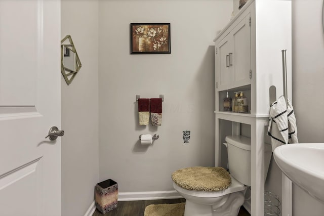 4196 Holstein Dr, Obetz, OH 43207 - half bathroom featuring wood finished floors, toilet, baseboards, and a sink