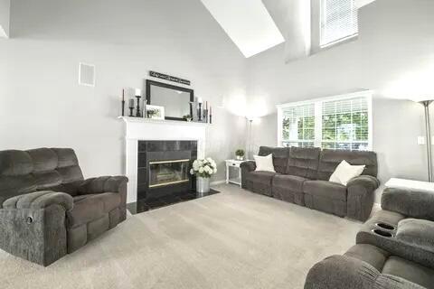 6004 Goldstone Dr, Grove City, OH 43123 - carpeted living room with a tile fireplace and high vaulted ceiling