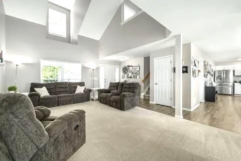 6004 Goldstone Dr, Grove City, OH 43123 - living area featuring high vaulted ceiling, carpet floors, baseboards, and stairway