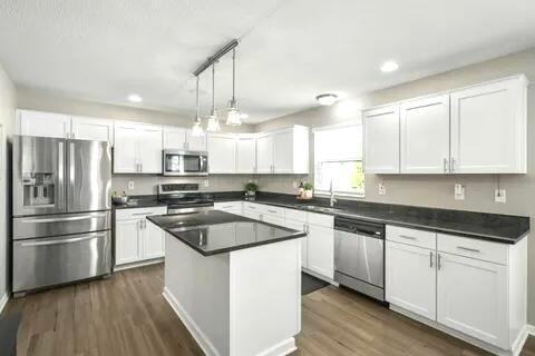6004 Goldstone Dr, Grove City, OH 43123 - kitchen featuring appliances with stainless steel finishes, white cabinets, a sink, dark wood-style flooring, and dark countertops