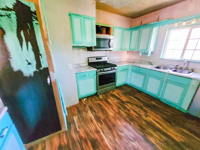 16251 State Route 678, Rockbridge, OH 43149 - kitchen with appliances with stainless steel finishes, a sink, dark wood finished floors, blue cabinets, and light countertops