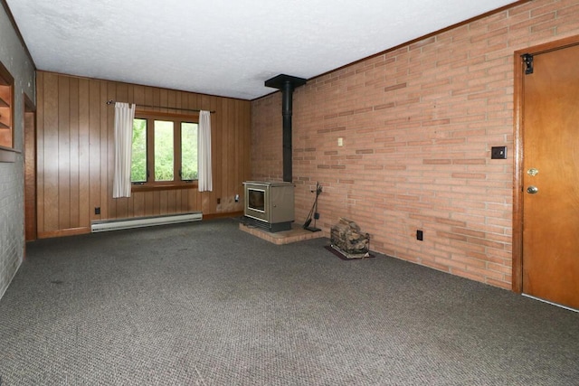 1266 Hanley Rd W, Mansfield, OH 44903 - unfurnished living room with a baseboard heating unit, a wood stove, carpet floors, wood walls, and a textured ceiling