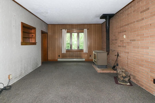 1266 Hanley Rd W, Mansfield, OH 44903 - unfurnished living room featuring a wood stove, dark carpet, a baseboard radiator, brick wall, and baseboards