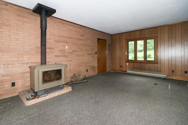 1266 Hanley Rd W, Mansfield, OH 44903 - unfurnished living room featuring a baseboard heating unit, a wood stove, carpet, and wood walls