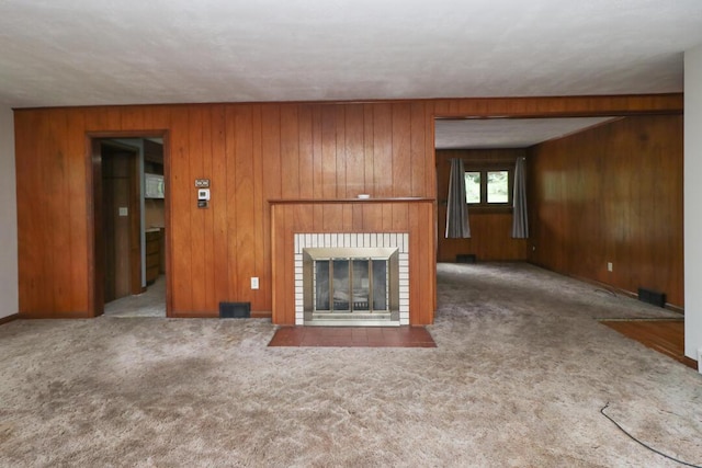 1266 Hanley Rd W, Mansfield, OH 44903 - unfurnished living room featuring carpet, wooden walls, and a brick fireplace