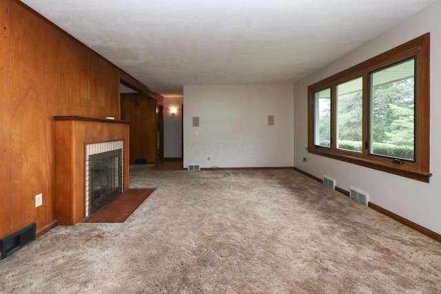 1266 Hanley Rd W, Mansfield, OH 44903 - unfurnished living room with a fireplace with flush hearth, carpet floors, wooden walls, and baseboards