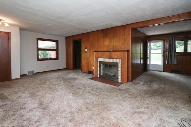 1266 Hanley Rd W, Mansfield, OH 44903 - unfurnished living room featuring wooden walls, a fireplace, carpet, and baseboards
