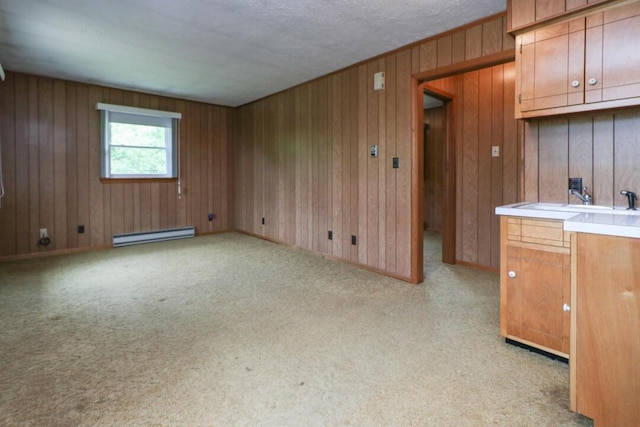 1266 Hanley Rd W, Mansfield, OH 44903 - unfurnished living room featuring a baseboard heating unit, light colored carpet, wooden walls, and a sink