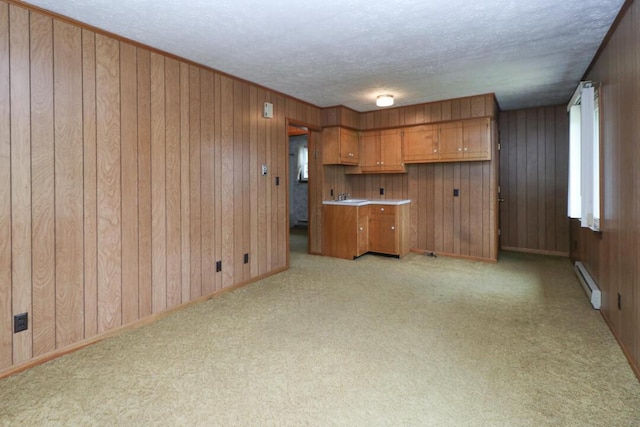 1266 Hanley Rd W, Mansfield, OH 44903 - kitchen with baseboard heating, brown cabinets, a textured ceiling, a sink, and wooden walls