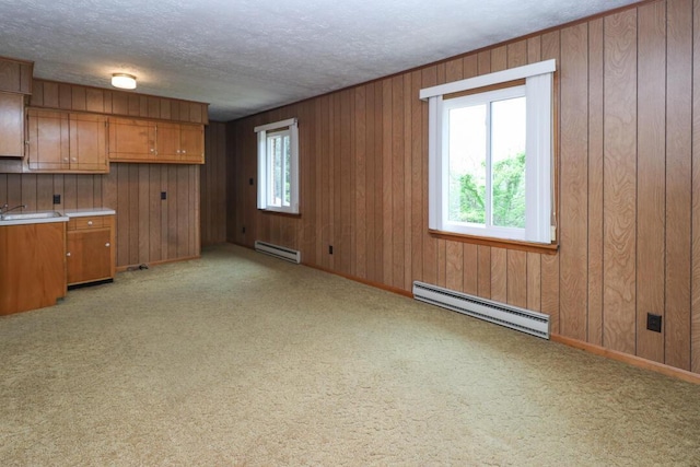 1266 Hanley Rd W, Mansfield, OH 44903 - kitchen featuring a baseboard radiator, baseboard heating, brown cabinets, light carpet, and wooden walls