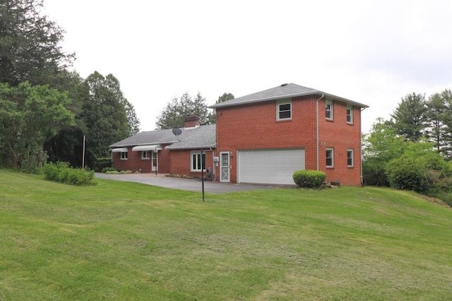 1266 Hanley Rd W, Mansfield, OH 44903 - rear view of house featuring brick siding, driveway, an attached garage, and a lawn