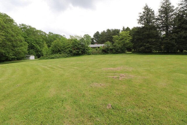 1266 Hanley Rd W, Mansfield, OH 44903 - view of grassy yard featuring a storage unit and an outdoor structure