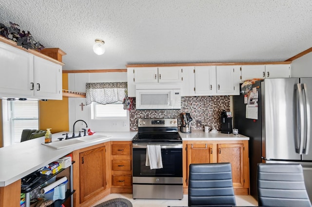 3200 Smeltzer Rd Unit 90, Marion, OH 43302 - kitchen featuring appliances with stainless steel finishes, a sink, a textured ceiling, light countertops, and a peninsula