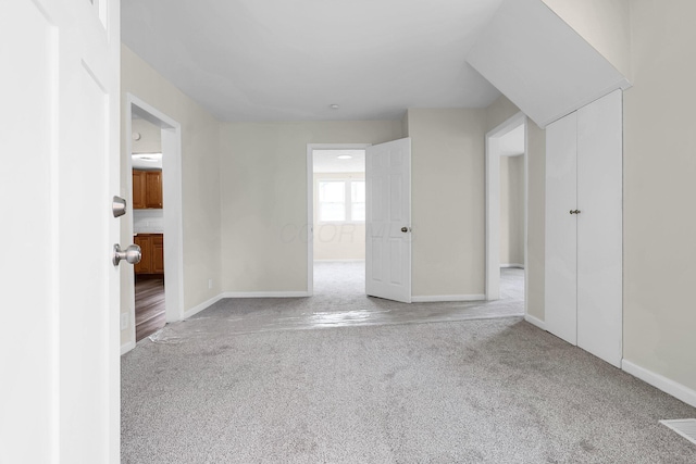 unfurnished room featuring carpet flooring and baseboards