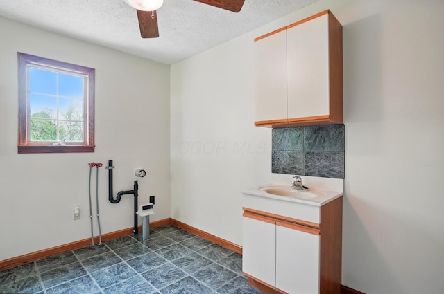 5870 Brook Rd NW, Baltimore, OH 43105 - laundry area with a textured ceiling, a ceiling fan, cabinet space, and baseboards