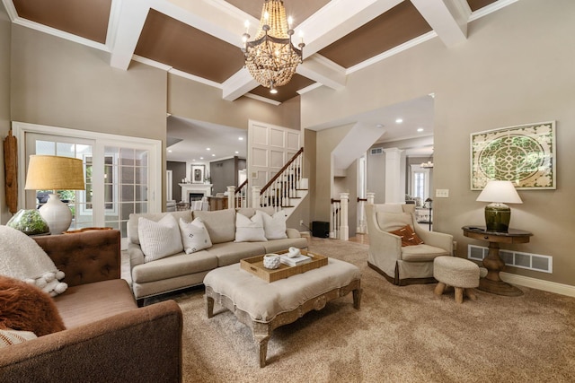 712 Riverbend Ave, Powell, OH 43065 - carpeted living room featuring a towering ceiling, beam ceiling, a chandelier, stairs, and plenty of natural light