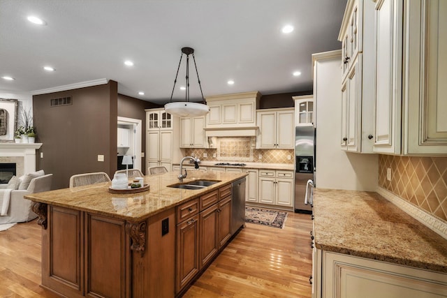 712 Riverbend Ave, Powell, OH 43065 - kitchen featuring cream cabinetry, appliances with stainless steel finishes, a sink, glass insert cabinets, and recessed lighting