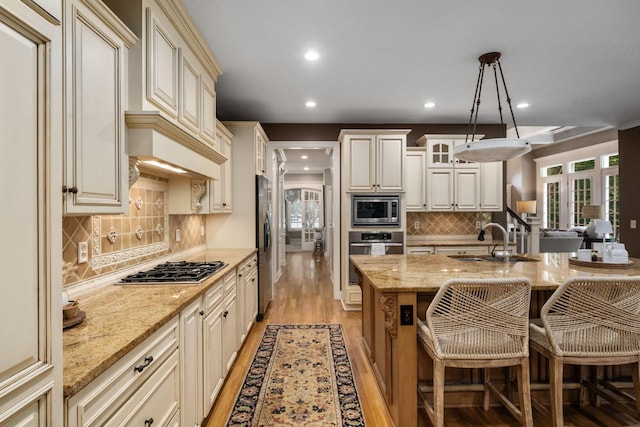 712 Riverbend Ave, Powell, OH 43065 - kitchen with stainless steel appliances, a sink, recessed lighting, light wood-style flooring, and tasteful backsplash