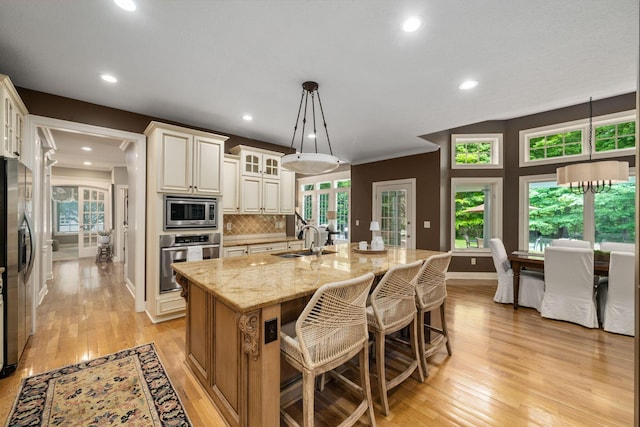 712 Riverbend Ave, Powell, OH 43065 - kitchen with appliances with stainless steel finishes, light stone countertops, light wood-style floors, tasteful backsplash, and recessed lighting