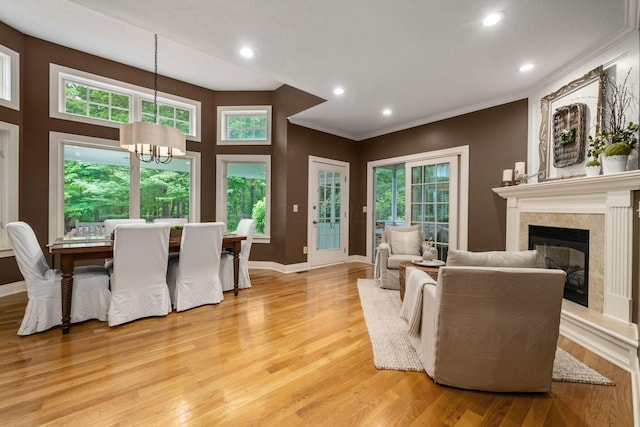 712 Riverbend Ave, Powell, OH 43065 - living area with light wood-type flooring, a chandelier, ornamental molding, a glass covered fireplace, and baseboards