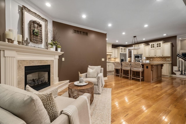 712 Riverbend Ave, Powell, OH 43065 - living area with a fireplace, light wood finished floors, ornamental molding, and recessed lighting