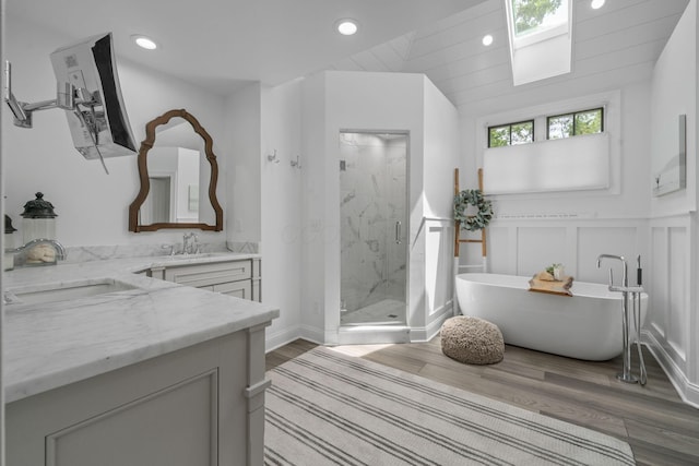 712 Riverbend Ave, Powell, OH 43065 - bathroom with vanity, a marble finish shower, wood finished floors, a soaking tub, and recessed lighting