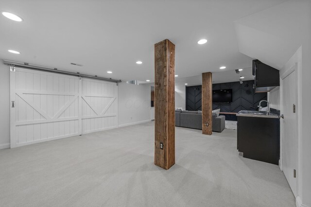 712 Riverbend Ave, Powell, OH 43065 - finished below grade area with a barn door, light colored carpet, recessed lighting, baseboards, and a sink
