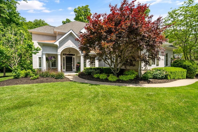 712 Riverbend Ave, Powell, OH 43065 - view of front of home featuring stucco siding, a front yard, and a shingled roof