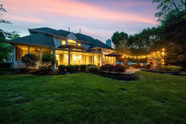 712 Riverbend Ave, Powell, OH 43065 - back of property at dusk with a lawn, outdoor lounge area, a chimney, and a patio