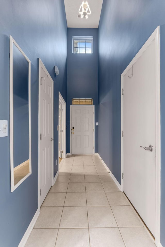 308 Postage Cir, Pickerington, OH 43147 - corridor featuring a towering ceiling, tile patterned floors, baseboards, and a chandelier