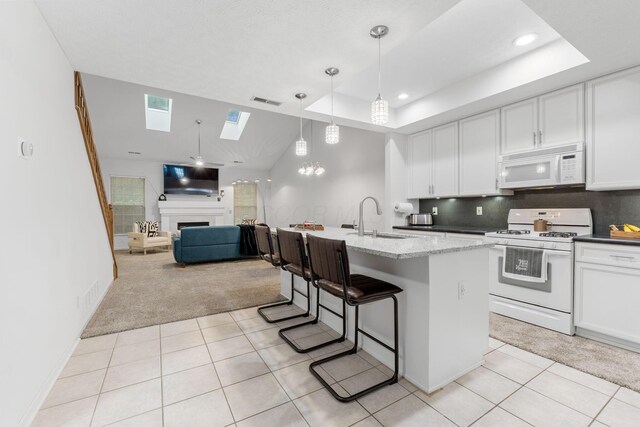 308 Postage Cir, Pickerington, OH 43147 - kitchen with white appliances, a skylight, a sink, light tile patterned floors, and white cabinets