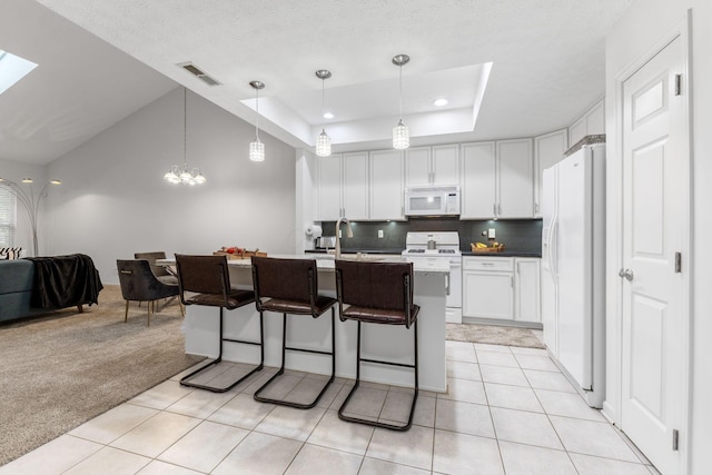 308 Postage Cir, Pickerington, OH 43147 - kitchen featuring white appliances, white cabinetry, light tile patterned floors, a kitchen breakfast bar, and light colored carpet